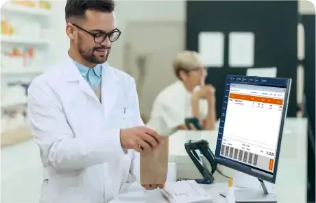 Farmacéutico atendiendo en mostrador utilizando un sistema de punto de venta para farmacia