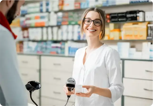 Farmacéutica sonriente escaneando el código de barras de un medicamento en el punto de venta para farmacia
